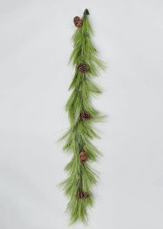 a green garland with pine cones hanging from it's side on a white wall