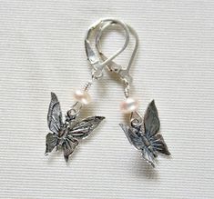 "Handcrafted dainty sterling silver butterfly dangle earrings make a great Mothers Day gift for daughter or birthday gift for Grandma! These cute butterfly earrings are handcrafted by me wire wrapping peach freshwater pearls to each sterling silver butterfly. Earrings hang approximately 3/4\" from sterling silver ear wires. Would make a great gift for any occasion! Handmade by me with love in my smoke-free home. I ship first class mail via the U.S. Postal Service worldwide. Please check out my o Silver Butterfly Jewelry For Birthdays, Silver Butterfly Jewelry For Birthday, Whimsical Butterfly Charm Earrings For Gift, Handmade Sterling Silver Butterfly Earrings, Handmade Silver Butterfly Earrings, Whimsical Silver Jewelry With Butterfly Charm, Christmas Gift For Grandma, Grandma Birthday Gift, Bloodstone Jewelry