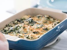 a casserole dish with broccoli and cheese in it on a table