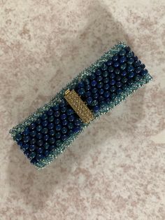 a blue beaded purse sitting on top of a table