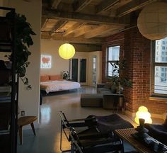 a living room filled with furniture next to a window covered in lights and hanging from the ceiling