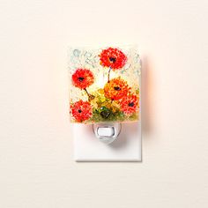 a light switch cover with flowers painted on the front and back of it, mounted to a white wall