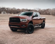 a large brown truck parked on top of a dirt field