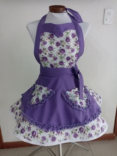 the apron is purple and white with flowers on it