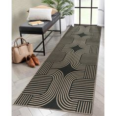 a black and white area rug with an abstract design on the floor in front of a window