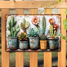 an old metal sign with potted cactuses on the front and side, hanging from a wooden fence