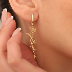 Elevate your style with our beautiful collection of Flower and Name Dangle Earrings. Handcrafted with high-quality materials, including 14K solid gold, 14K plated gold, 925 silver and gold, rose gold, and white gold, these earrings are sure to add a touch of elegance to any look. With their personalized design featuring a flower and a name, our earrings make for a unique and thoughtful gift to yourself or a loved one. Perfect for any special occasion, these handmade earrings are the perfect way 14k Gold Earrings With Flower Charm For Gift, Gold Earrings With Birth Flower For Anniversary, Gold Birth Flower Earrings For Anniversary, Yellow Gold Flower-shaped Hoop Earrings Gift, Yellow Gold Flower Shaped Hoop Earrings As Gift, Yellow Gold Birth Flower Earrings Gift, Elegant Birth Flower Earrings As A Gift For Her, 14k Gold Flower Earrings For Gift, Flower Charm Earrings For Mother's Day Anniversary