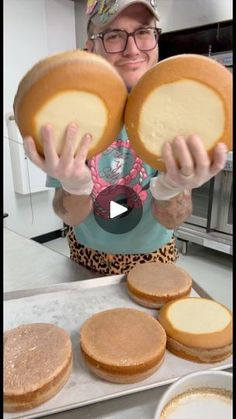 a woman is holding up some cakes in front of her