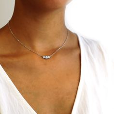 Our Marigold three-stone diamonds are set in beaded pods. It is suspended from the cable chain. About this necklace: Made in solid 14k white gold (rhodium plated) choose from different weights, 1.1ctw Total 1.1ctw three diamonds (shown) 0.6ct round center, (2) 0.25ct sides Color G-H, clarity SI1 Your choice of a 16-inch diamond-cut 1.4mm cable chain with lobster Please allow 3-4 weeks for shipping. If you need it sooner, we can sometimes expedite. Thinking of using a different stone? We can cust Luxury Minimalist Three Stone Jewelry, Luxury White Gold Three Stone Necklace, Luxury Gold Three Stone Necklace, Luxury Three Stone Minimalist Jewelry, Luxury Three-stone Necklaces For Women, 3 Stone Diamond Necklace, Three Diamond Necklace, 3 Diamond Necklace, Free Spirit Style