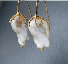 Large freshwater iridescent white baroque pearl drop earrings for women in 18k gold plated on 925 sterling silver that would make a real statement on your wedding day! With amazingly beautiful lustre and aaa grade, these elegant earrings would make exquisite jewelry gifts for a bride or mother of the bride or groom These high quality cultured pearls come naturally in different shapes but these pairs have been bought specially as a closely matched pair. The natural variations in shape adds to the White Statement Earrings, Jewelry For Bride, Pearl Drop Earrings Bridal, Bridal Statement Earrings, Pearl Earrings Gold, Wedding Jewelry For Bride, Freshwater Pearl Drop Earrings, Iridescent White, Gold Wedding Jewelry