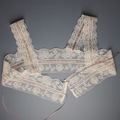 An antique filet lace camisole yoke, unused and in perfect condition.  The lace has been threaded with a new dusky rose coloured ribbon. Laid flat and open the yoke is 91 cm [36 cm]  wide and  25 cm [10"]deep. [Top of the shoulder strap to the bottom of the lace.] The lace is suitable for topping a chemise, nightgown or even a light summer dress. The lace is soft white in colour. Any excess postage on multiple orders will be refunded in full.       Antique and vintage items will rarely be perfec Lace Camisole Bra With Lace Trim, Lace Underbust Camisole With Lace Trim, Lace Trim Camisole For Daywear, Lace Camisole With Lace Trim For Daywear, Elegant Lace Underbust Camisole, Delicate Lace Bra With Lace Trim, Delicate Lace Trim Camisole Top, Feminine Lace Camisole With Patchwork, Feminine Lace Camisole With Lace Patchwork