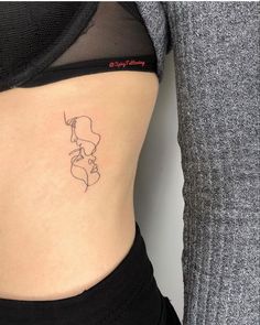 a woman's stomach with a small tattoo on her lower back and the side