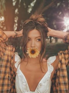 a woman with a flower in her mouth is posing for the camera while wearing plaid shirts