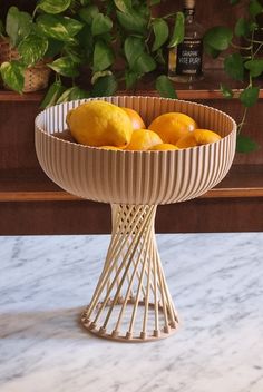 a bowl filled with lemons sitting on top of a table