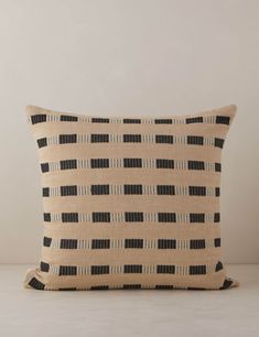 a black and white pillow sitting on top of a table