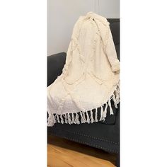 a white blanket sitting on top of a black couch