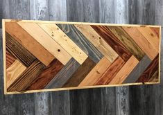 a wooden wall hanging on the side of a wood planked wall with different colors and shapes