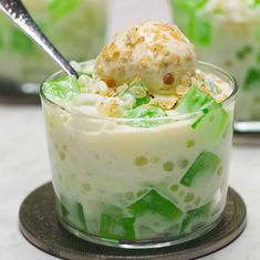 a dessert in a glass dish with ice cream and green leaves on top, topped with a scoop of ice cream