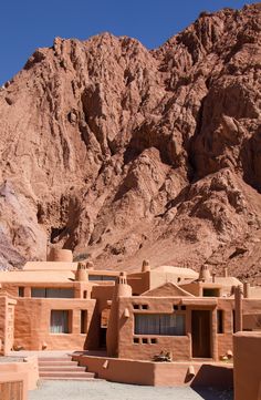 an adobe - style house in the desert with mountains in the background