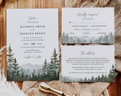 the wedding stationery is laid out on a wooden table