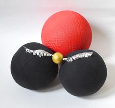 three black balls with silver wings and a red ball on the bottom one has a gold bead