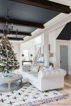 a living room filled with furniture and a christmas tree in the middle of the room