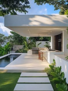 an outdoor kitchen and dining area in a modern style home with water feature on the side