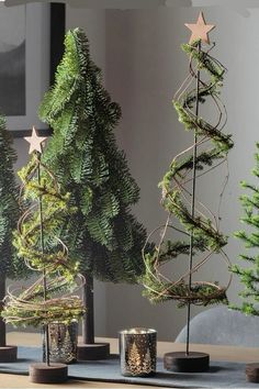 three small christmas trees sitting on top of a table