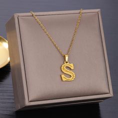 Show off your unique style with this stainless steel initial necklace! Customize with a letter of your choice in gold color to create a personalized look that is sure to stand out. Its chunky letter design is a stylish addition to any jewelry collection. Gold Initial Necklace In Stainless Steel, Gold Stainless Steel Initial Necklace, Gold Initial Pendant Necklace With Letter Print, Gold Initial Necklace With Letter Print As Gift, Tan Monogram Initial Pendant Necklace, Gold Letter Initial Necklace As Personalized Gift, Tan Initial Pendant Necklace, Gold Trendy Initial Necklace, Stainless Steel Initials Name Necklace