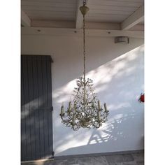 a chandelier hanging from the ceiling in front of a white wall and door