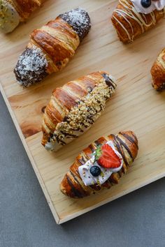 croissants and pastries are arranged on a cutting board, ready to be eaten