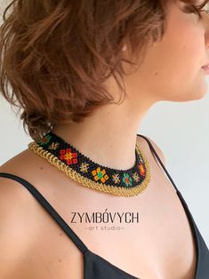 a woman wearing a black top with a colorful beaded necklace on her back neck