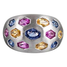 Satin-finished 18 karat white gold displays oval faceted sapphires of blues, pinks and yellows in hexagonal bezels. This piece is unusual and beautiful with the ideal balance of playfulness and sophistication. The sapphires weigh 3.78 carats in total. Size 6.25 can be resized on request. Ring Blue Sapphire, Dome Ring, Purple Sapphire, Domed Ring, Platinum Ring, Yellow Sapphire, Natural Sapphire, Princess Cut Diamonds, Brilliant Diamond