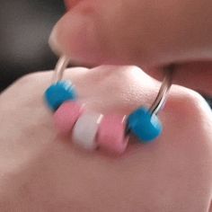 a close up of a baby's pacifier attached to its nose with two blue, white and pink beads