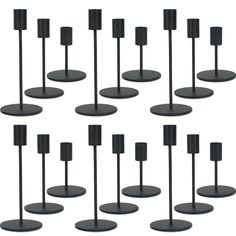 eight black candles are arranged in rows on the same stand, each with one candle holder