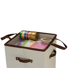 a canvas storage box with tape, scissors and other crafting supplies in the lid