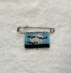 a blue and black beaded keychain with a silver metal hook on a white background