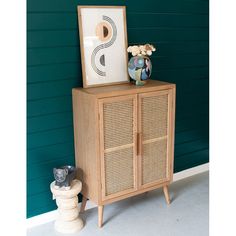 a wooden cabinet sitting next to a green wall