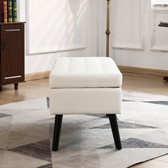 a white ottoman sitting on top of a rug