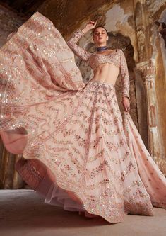 Editor's Note The peach georgette lehenga set with chevron design embroidery in foil, resham, mirror, and gota is a perfect blend of traditional and modern. The full-sleeved embroidered blouse adds an elegant touch, and the matching dupatta completes the look. Fabric: Georgette, lining: crepe lining Color: Peach Components: Lehenga, blouse and dupatta Occasion: Sangeet and wedding Disclaimer: Product color may slightly vary due to photographic lighting sources or your monitor setting. Care: Dry Glam Lehenga, Nude Lehenga, Peplum Sharara, Seema Gujral, Ridhi Mehra, Gold Lehenga, Chevron Mirror, Raw Silk Lehenga, Full Sleeve Blouse