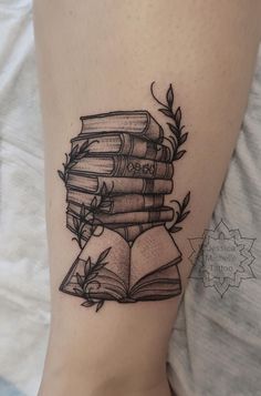 a black and white tattoo with books on it