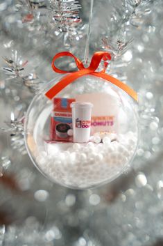 a christmas ornament hanging from a tree filled with white balls and candies