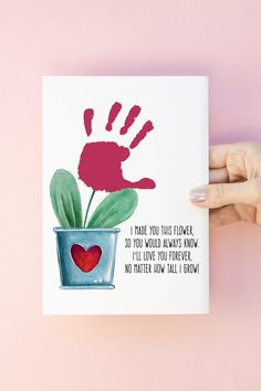 a hand holding up a card with a plant in it