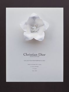 a white paper flower with the words christian dior on it