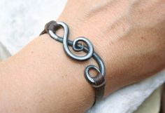 a person's arm with a bracelet on it and a knot in the middle