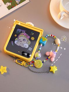 an electronic device is sitting on a table with beads and charms around it's edges