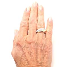 an older woman's hand with a ring on her left wrist, against a white background