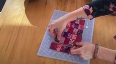 a person cutting up some fabric on top of a table