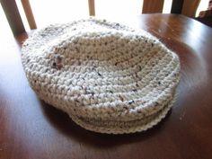 a crocheted hat sitting on top of a wooden table