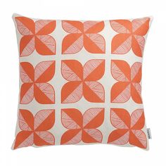 an orange and white decorative pillow on a white background with red circles in the middle